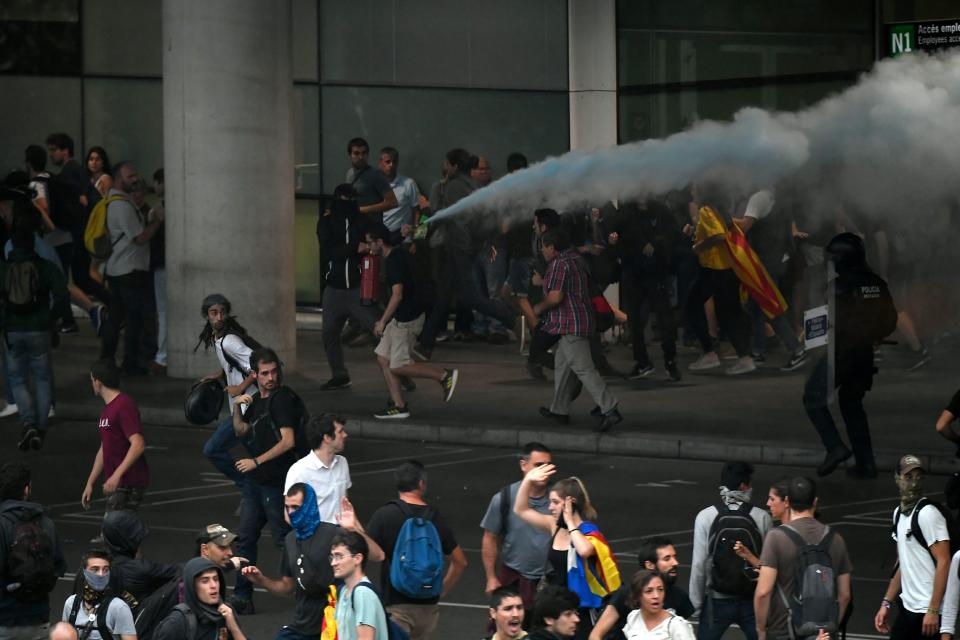 Un manifestante descarga un extintor contra los mossos (Photo by LLUIS GENE/AFP via Getty Images)