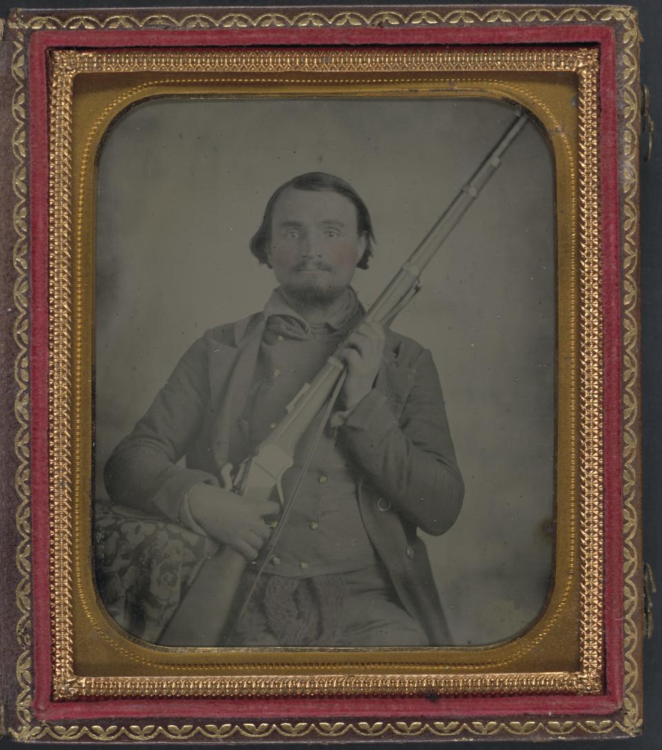 A Civil War soldier is pictured with his Sharps rifle.