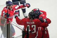 CORRECTS THAT GOAL WAS SCORED BY NIC DOWD, INSTEAD OF T.J. OSHIE - Washington Capitals left wing Alex Ovechkin (8) comes in to celebrate with right wing Tom Wilson (43), right wing T.J. Oshie (77) and defenseman Justin Schultz (2) after Nic Dowd's overtime goal on a deflection of a shot by Oshie in Game 1 of an NHL hockey Stanley Cup first-round playoff series against the Boston Bruins, Saturday, May 15, 2021, in Washington. The Capitals won 3-2. (AP Photo/Alex Brandon)