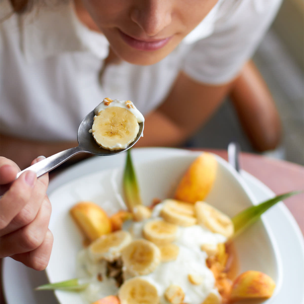woman eating a bowl of banana fruit with yogurt