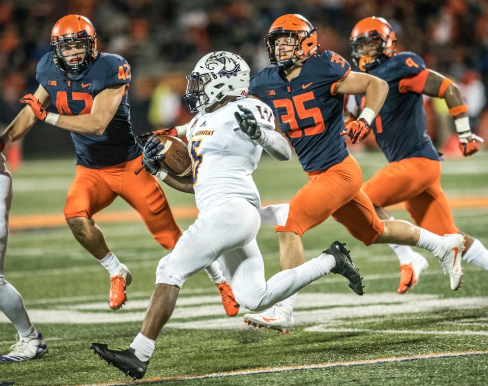 Western Illinois' Steve McShane (5) runs the ball as he is pursued by Illinois' Michael Marchese (42),  Jake Hansen (35) and Dele Harding (9) during a college football game Saturday, Sept. 8, 2018 in Champaign, Illinois.