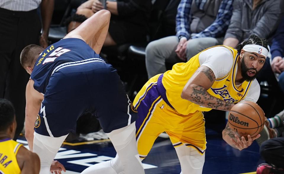 O atacante do Lakers, Anthony Davis, à direita, tenta passar a bola depois de girar em torno do pivô do Nuggets, Nikola Jokic, durante o jogo 5.