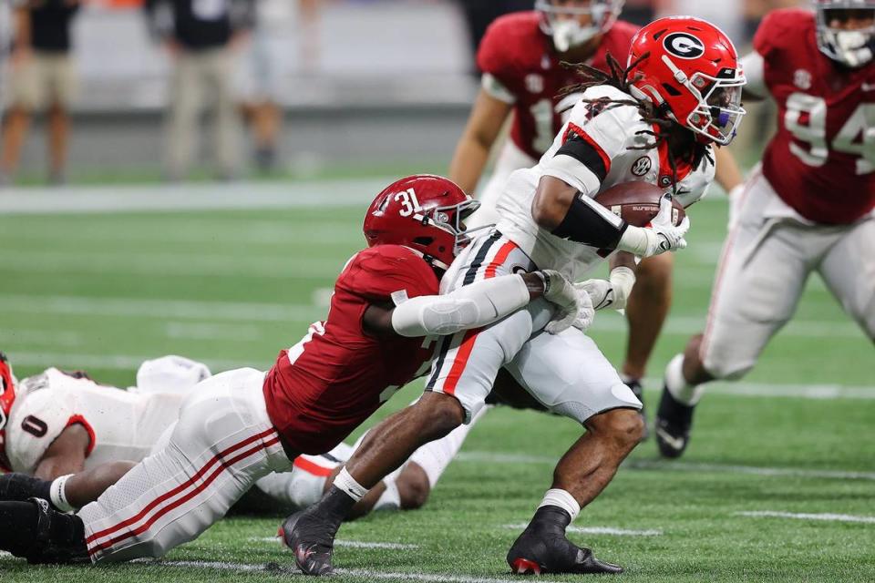 Will Anderson Jr. #31 of the Alabama Crimson Tide tackles James Cook #4 of the Georgia Bulldogs during the third quarter of the SEC Championship game against the at Mercedes-Benz Stadium on December 04, 2021 in Atlanta, Georgia.