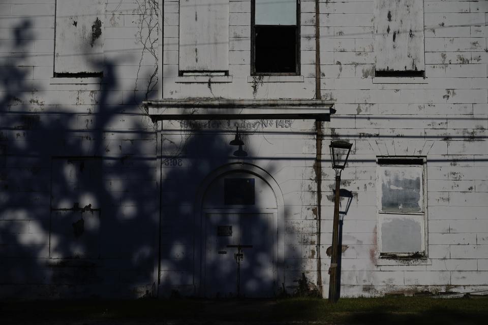 Sunlight falls on an abandoned building on Wednesday, Dec. 6, 2023, in Prichard, Ala. The struggling city loses 60% of its treated water through an aging distribution system. Communities nationwide lose trillions of gallons. (AP Photo/Brynn Anderson)