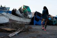 Mohamed Fane is seen in a cemetery of abandoned wooden boats in Arinaga