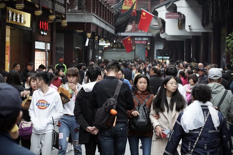 People walking around a busy shopping street in Shanghai.