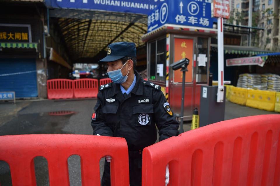 A police officer stands guard outside of Huanan Seafood Wholesale market where the coronavirus was detected in Wuhan.