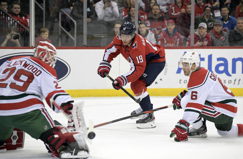 New Jersey Devils goaltender Mackenzie Blackwood (29) deflects a shot by Washington Capitals center Nicklas Backstrom (19) as Devils defenseman Andy Greene (6) also defends during the first period of an NHL hockey game Friday, Dec. 20, 2019, in Newark, N.J. (AP Photo/Bill Kostroun)