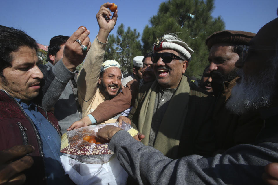 Malik Tariq Awan, center right, an independent candidate, celebrates with supporters after his victory in the parliamentary elections, in Peshawar, Pakistan, Friday, Feb. 9, 2024. The results of Pakistan's elections were delayed a day after the vote that was marred by sporadic violence, a mobile phone service shutdown and the sidelining of former Prime Minister Imran Khan and his party. (AP Photo/Muhammad Sajjad)