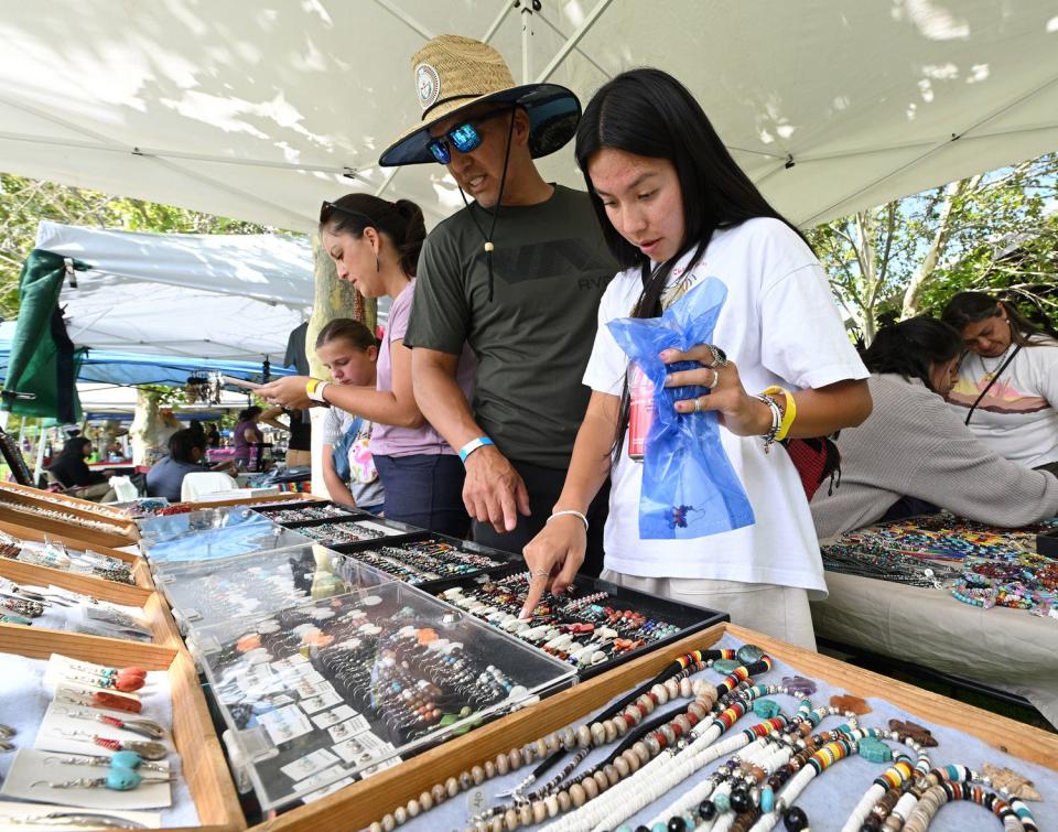 Kansas John looks at crafts with his daughter Tyler John at Utah Native Market Days at Thanksgiving Point in Lehi on Friday. All proceeds are going to Native student scholarships. There was hoop dancing, food and crafts.