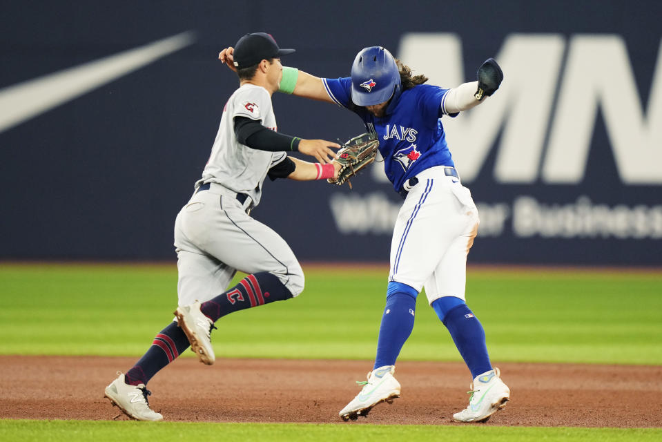 Cleveland Guardians third baseman Tyler Freeman, left, tags out Toronto Blue Jays' Bo Bichette in a rundown during the fifth inning of a baseball game in Toronto on Saturday, Aug. 26, 2023. (Frank Gunn/The Canadian Press via AP)