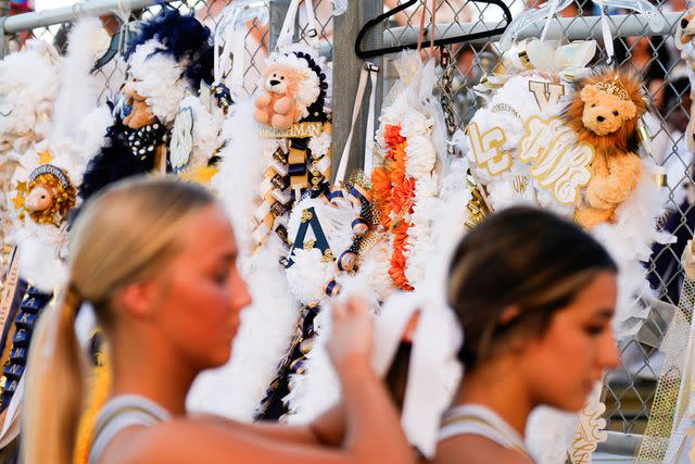 <p>Jason Fochtman/Houston Chronicle via Getty </p> Homecoming mums hang from the stands at a football game near Houston.