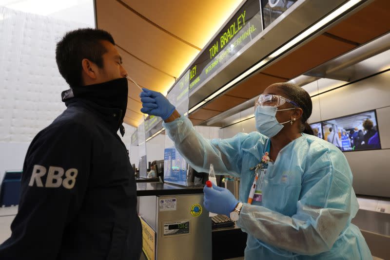 Scott Fujii, 34, is given a 24-hour rapid coronavirus test by nurse Caren Williams at Tom Bradley international terminal at LAX airport, as the global outbreak of the coronavirus disease (COVID-19) continues, in Los Angeles