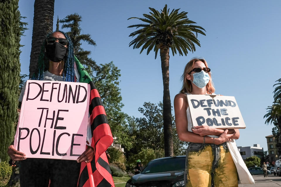 Protesters hold placards during a demonstration in April outside of Los Angeles Mayor Eric Garcetti's home to protest his proposal to restore funding to the Los Angeles Police Department. (Photo: Stanton Sharpe/SOPA Images/LightRocket via Getty Images)