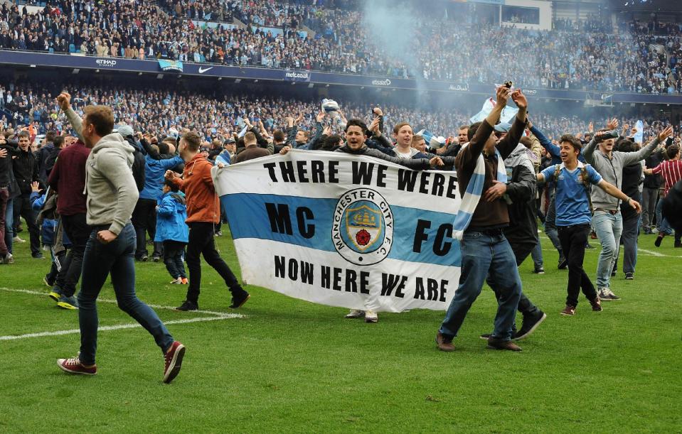 Manchester City's fans invade the pitch after the final whistle, as Manchester City are crowned Premier League Champions after the English Premier league soccer match between Manchester City and West Ham United at the Etihad Stadium, Manchester, England, Sunday, May 11, 2014. (AP Photo/Rui Vieira)