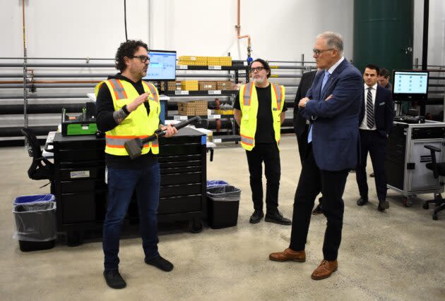 First Mode’s director of manufacturing, Bill Huntington, explains the workings of a digital torque wrench to Washington Gov. Jay Inslee. (GeekWire Photo / Alan Boyle)