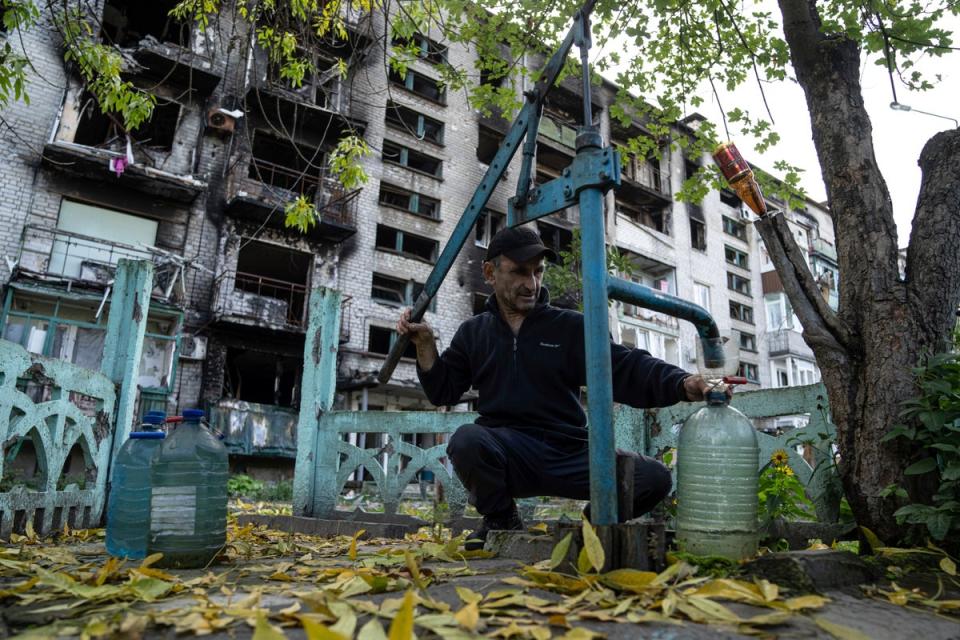 A man pumps water in the recpatured city of Lyman (Copyright 2022 The Associated Press. All rights reserved)