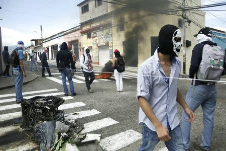 Masked students block a street as they clash with national guards during a protest against the government in San Cristobal January 14, 2015. REUTERS/Carlos Eduardo Ramirez