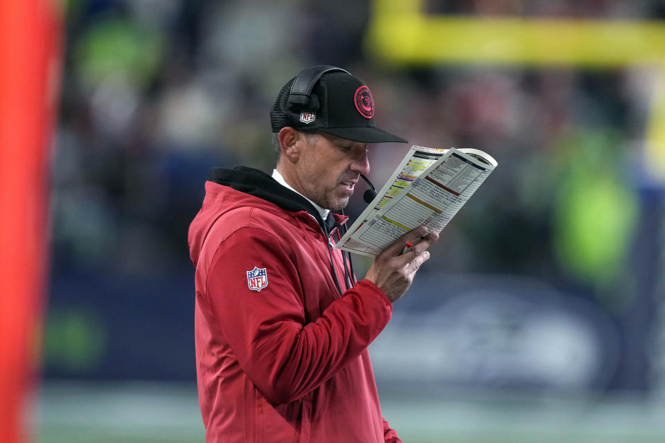 San Francisco head coach Kyle Shanahan looks over his plays during the first half of an NFL football game against the Seattle Seahawks, Thursday, Nov. 23, 2023, in Seattle. (AP Photo/Stephen Brashear)