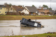 A camping trailer sits in a retention pond where a tornado was reported to pass along Mickey Gilley Blvd., near Fairmont Parkway, Tuesday, Jan. 24, 2023, in Pasadena, Texas. (Mark Mulligan/Houston Chronicle via AP)