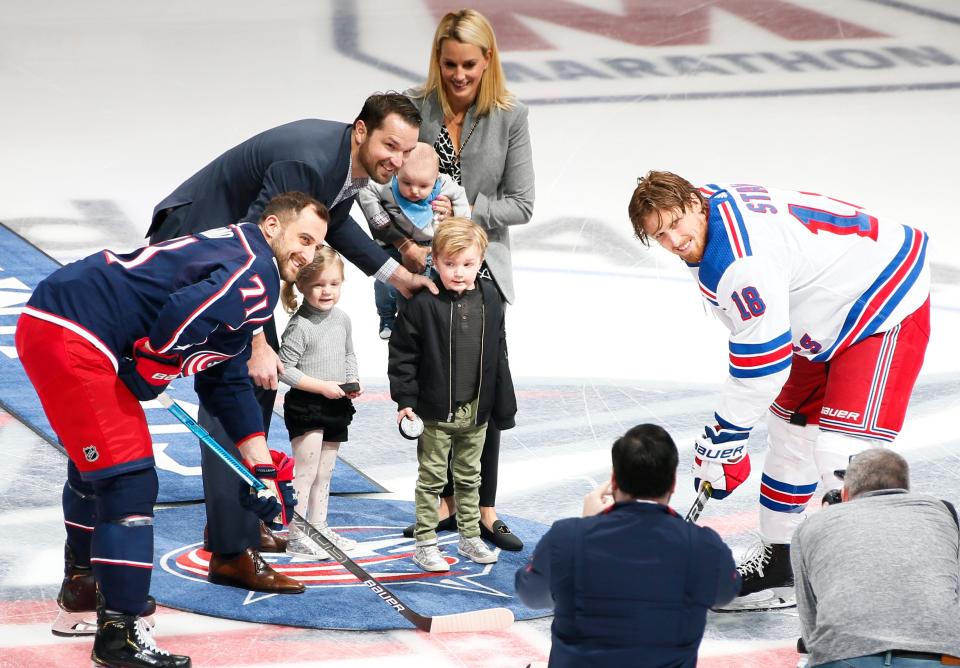 Rick Nash and his family pose with Blue Jackets left wing Nick Foligno (71) and Rangers defenseman Marc Staal for the puck drop before a game in 2019.