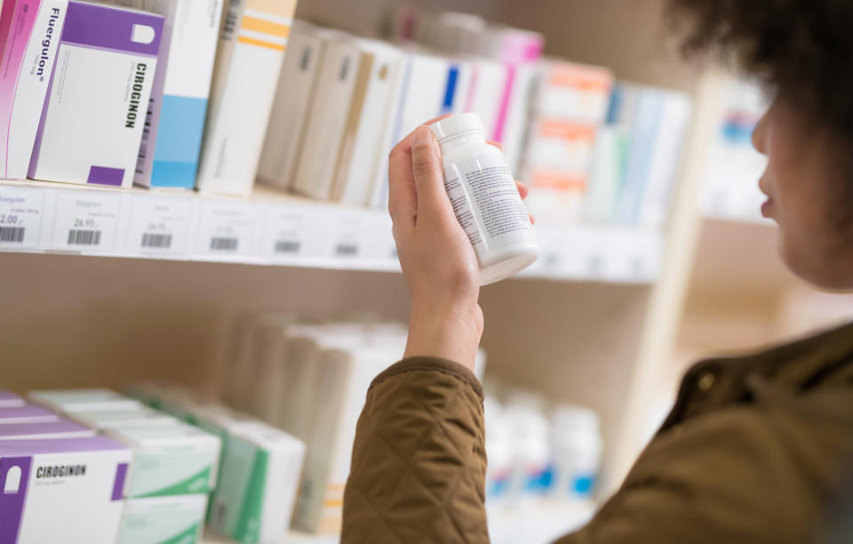 Young Woman Choosing For Supplement In Drugstore