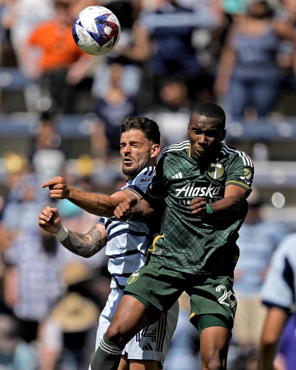 Sporting Kansas City defender Tim Leibold, left, and Portland Timbers defender Juan David Mosquera (29) battle for the ball during the second half of an MLS soccer match Sunday, May 28, 2023, in Kansas City, Kan. Sporting Kansas City won 4-1. (AP Photo/Charlie Riedel)