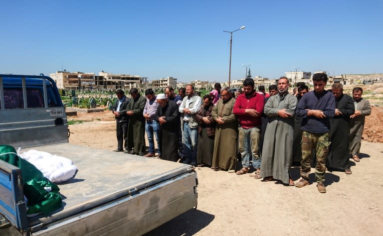 Syrians hold funeral prayers before they bury the bodies of victims of a suspected chemical attack in the town of Khan Sheikhun