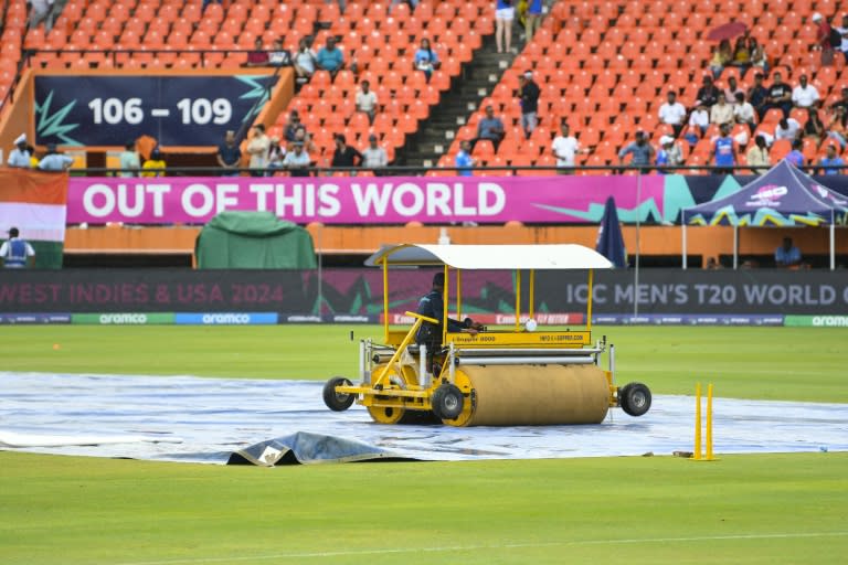 Delayed start: Groundstaff mop up after rain delayed the start of the T20 World Cup semi-final between India and England at the Providence Stadium, Guyana (Randy Brooks)