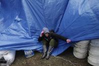 Gina Kohm tries to keep a tarp from blowing away which covers a pile of donated supplies at an aid station in the New Dorp section of Staten Island, New York, Wednesday, Nov. 7, 2012. Residents of New York and New Jersey who were flooded out by Superstorm Sandy are waiting with dread Wednesday for the second time in two weeks as another, weaker storm heads toward them and threatens to inundate their homes again or simply leave them shivering in the dark for even longer. (AP Photo/Seth Wenig)