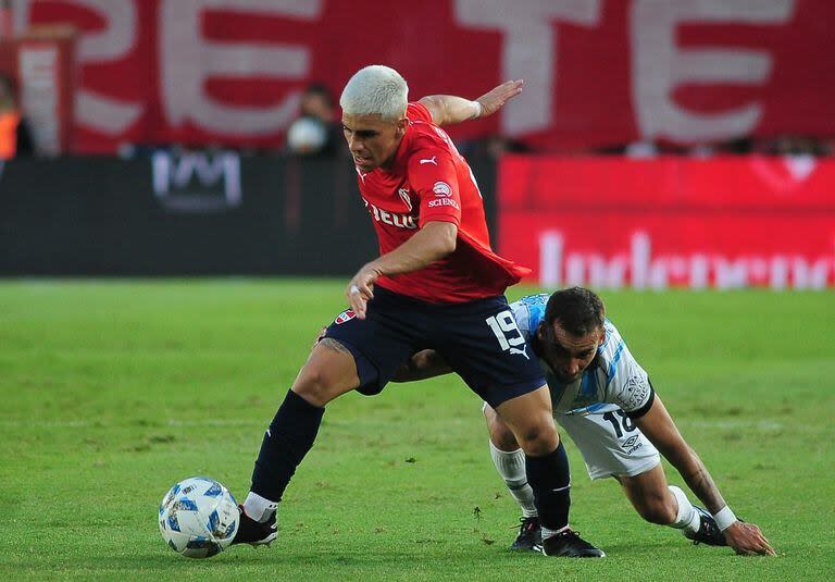 Alex Luna se escapa ante la marca de Tesuri; escena del partido que disputaron Independiente y Atlético Tucumán