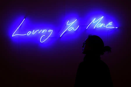 An employee poses as she views 'Loving You More' by Tracey Emin, which forms part of a forthcoming charity auction for the survivors of the London Grenfell Tower fire, at Sotheby's in London, Britain, October 12, 2017. REUTERS/Toby Melville