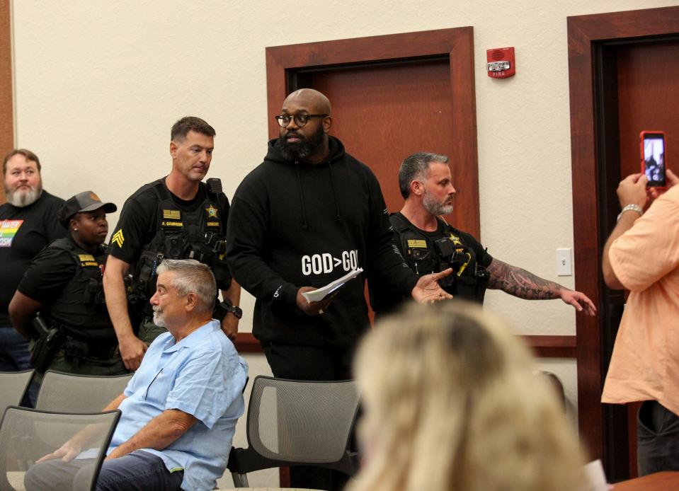 John Amanchukwu is escorted out of an Indian River County School board meeting after attempting to read passages from a school library book that were sexually explicit, Monday, Aug. 28, 2023.