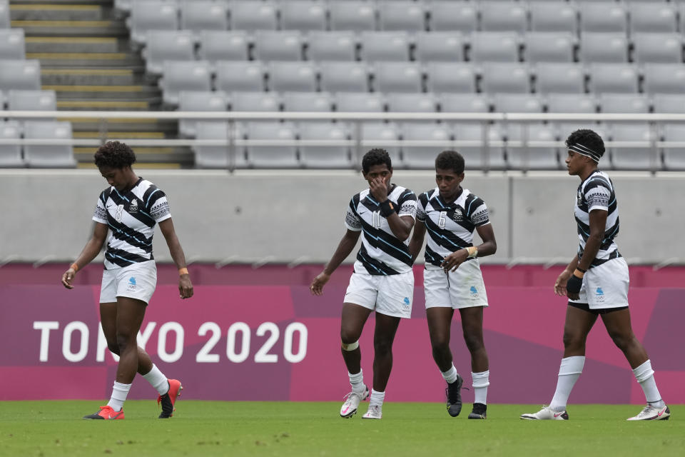 Fiji players walk on the pitch after losing to New Zealand in extra time in their women's rugby sevens semifinal match at the 2020 Summer Olympics, Saturday, July 31, 2021 in Tokyo, Japan. (AP Photo/Shuji Kajiyama)