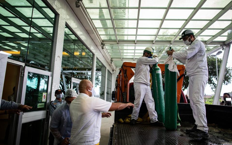 Workers carry oxygen cylinders at the Getulio Vargas University Hospital in Manaus - Raphael Alves/EPA-EFE/Shutterstock 