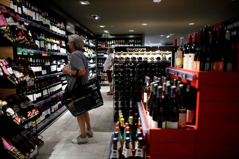 FILE PHOTO: A customer browses bottles of wine for sale inside a Monoprix supermarket operated by Casino Group, in Paris