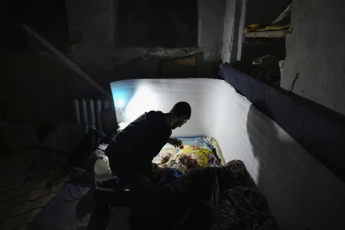 A man plays with a baby in a bomb shelter in Mariupol. 