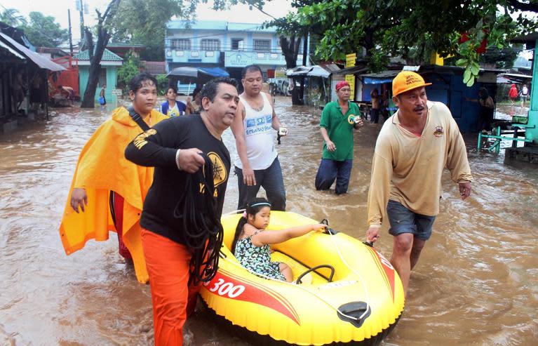 Residents carry a girl on a rubber raft in flood-ravaged Olongapo City, Philippines on September 23, 2013