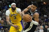 Los Angeles Lakers' Anthony Davis knocks the ball from Milwaukee Bucks' Giannis Antetokounmpo during the second overtime of an NBA basketball game Tuesday, March 26, 2024, in Milwaukee. The Lakers won 128-124 in double overtime. (AP Photo/Morry Gash)