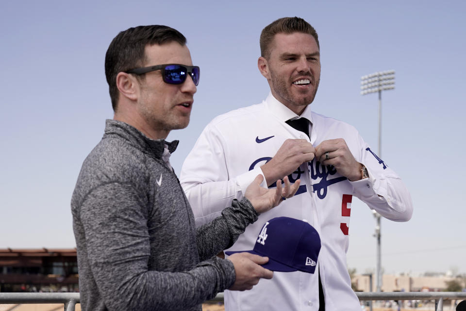 Los Angeles Dodgers president of baseball operations Andrew Friedman, left, announces the arrival of free agent Freddie Freeman during a news conference at spring training baseball, Friday, March 18, 2022, in Glendale, Ariz. (AP Photo/Charlie Riedel)