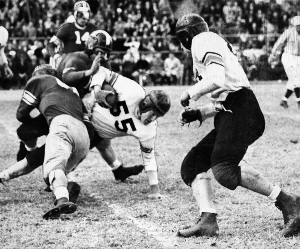 Oklahoma A&M University running back Bob Fenimore is stopped by OU's Homer Sparkman (back to camera) and Bob Mayfield during the Aggie's 28-6 victory over the University of Oklahoma Sooners at Taft Stadium. Staff photo taken Nov. 25, 1944.