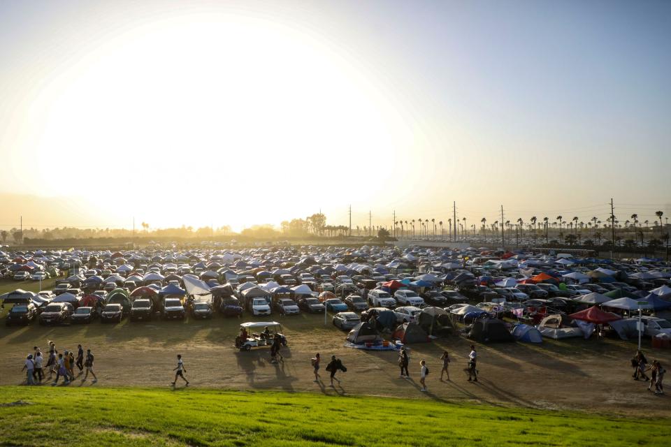 Festivalgoers walk from a car camping area along the red path at the Coachella Valley Music and Arts Festival in Indio, Calif., Saturday, April 16, 2022.