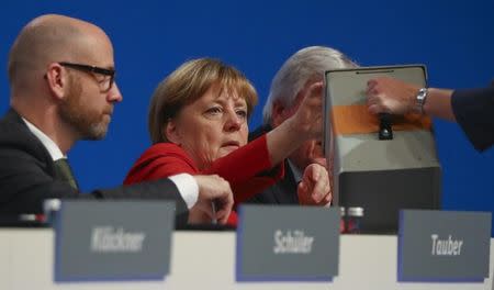 Peter Tauber, secretary general of the conservative Christian Democratic Union party CDU looks on as German Chancellor and CDU leader Angela Merkel casts her vote at the CDU party convention in Essen, Germany, December 6, 2016. REUTERS/Kai Pfaffenbach
