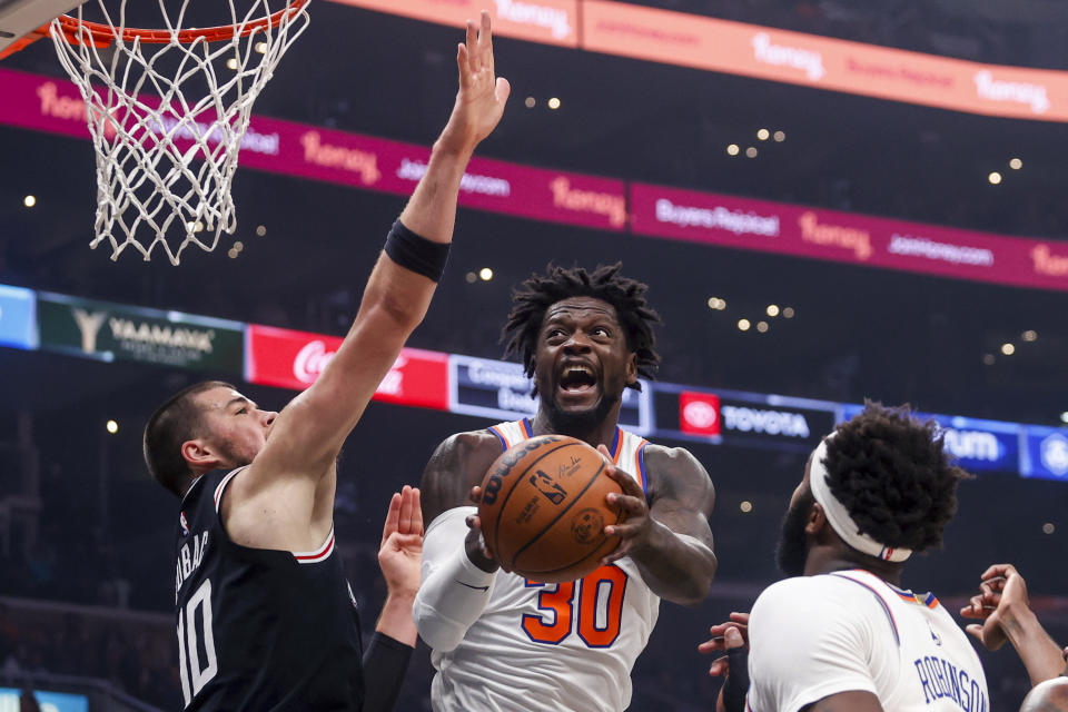 New York Knicks forward Julius Randle, center, goes to basket under pressure from Los Angeles Clippers center Ivica Zubac, left, during the first half of an NBA basketball game Saturday, March 11, 2023, in Los Angeles. (AP Photo/Ringo H.W. Chiu)