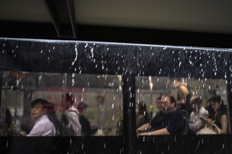 Rain falls as passengers sit in a bus during the morning commute in Singapore, Thursday, July 20, 2023. Across the island, 17 reservoirs catch and store rainwater, which is treated through a series of chemical coagulation, rapid gravity filtration and disinfection. (AP Photo/David Goldman)