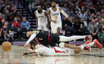 Los Angeles Clippers guard Amir Coffey, bottom, and Portland Trail Blazers guard Anfernee Simons dive for the ball during the second half of an NBA basketball game in Portland, Ore., Wednesday, March 20, 2024. (AP Photo/Craig Mitchelldyer)