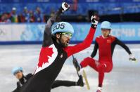 Canada's Charles Hamelin celebrates winning as China's Chen Dequan (back R) and J.R. Celski of the U.S. (bottom L) fall, during the men's 1,500 metres short track speed skating race finals at the Iceberg Skating Palace during the 2014 Sochi Winter Olympics February 10, 2014. REUTERS/David Gray (RUSSIA - Tags: OLYMPICS SPORT SPEED SKATING TPX IMAGES OF THE DAY)