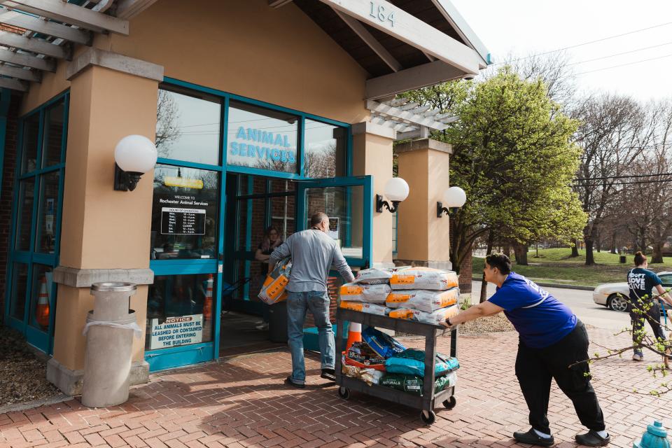 On Wednesday, Rochester Animal Services workers bring in a cartload of donated dog food.