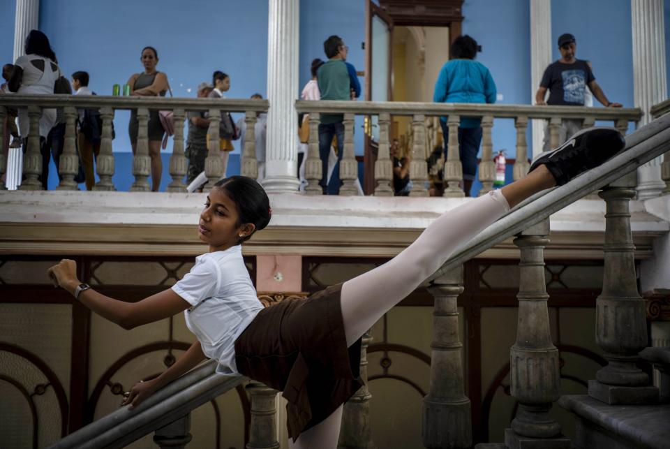 A ballet student poses for a friend to take photos, at the national ballet school in Havana, Cuba, Thursday, Dec. 12, 2019. The Soviet-style system that recruits children into a system of increasingly selective state dance schools has produced hundreds of elite dancers including Lorna Feijoo, Rolando Sarabia, Taras Domitro, Anette Delgado and Carlos Acosta. (AP Photo/Ramon Espinosa)