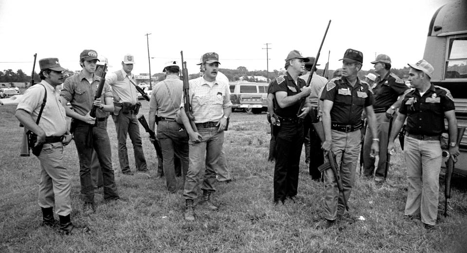 Officers gather near Locust Grove while searching for a suspect in the Camp Scott Girl Scout murders in June 1977.